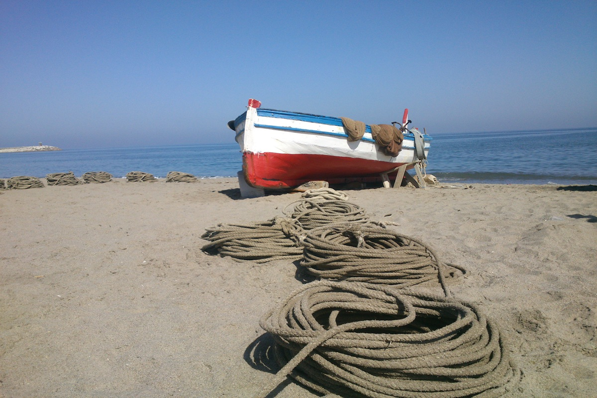 Postal marenga: j&aacute;bega
Desde hace varios siglos el arte de la j&aacute;bega ha dominado en las playas andaluzas, siendo su perfil, su traj&iacute;n y sus artefactos los que m&aacute;s se repet&iacute;an en nuestras costas. En la Andaluc&iacute;a mediterr&aacute;nea, la &ldquo;marenga&rdquo;, se denominaba rebalaje a ese espacio colonizado por este arte de tiro desde la playa, prohibido desde los principios de los a&ntilde;os ochenta. Sin embargo, en la playa a poniente del puerto de Atunara (L&iacute;nea de la Concepci&oacute;n), todav&iacute;a se puede disfrutar de esta estampa, injertada en el presente. Las betas (sogas) para las faenas de tiro del arte de j&aacute;bega se hallan dispuestas en esta playa solitaria de amanecida, a la espera de que empiece el lance para la captura de peque&ntilde;os pel&aacute;gicos que se acercan al rompiente de las olas. La modesta embarcaci&oacute;n impresiona en su altiva sencillez, quiz&aacute; consciente de que es la &uacute;ltima de las j&aacute;begas andaluzas que pueden seguir pescando.